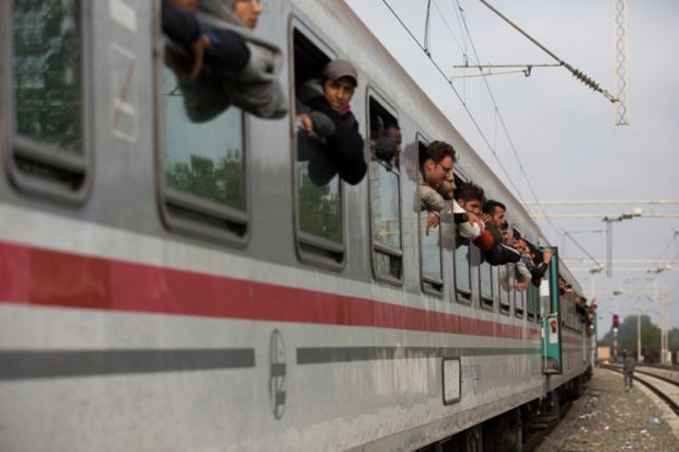 Syrian refugees leaning out of train windows