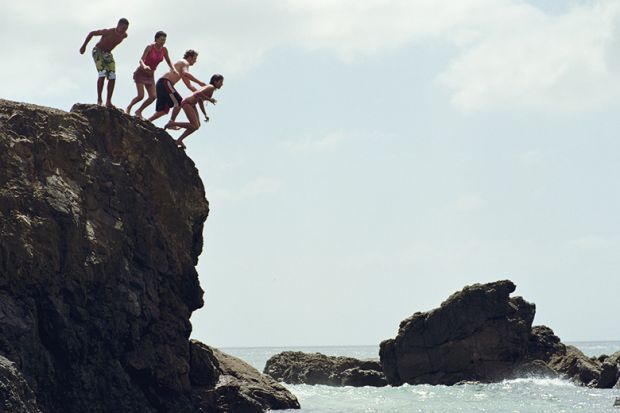 Group of people jumping in to the sea from a cliff