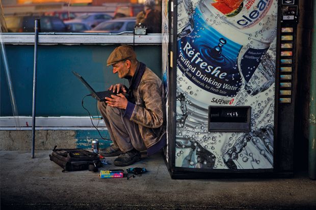 Man using computer next to vending machine