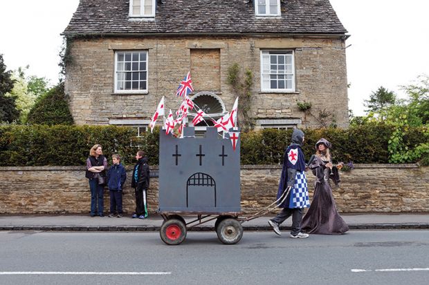 people dressed in medieval costume towing a homemade castle