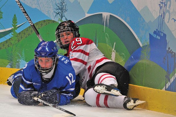 two female ice hockey players lying on the ice