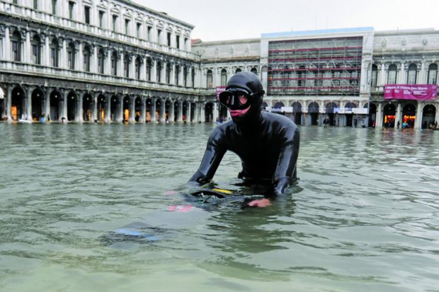 Scuba diver wading in floodwater, Saint Mark's Square, Venice