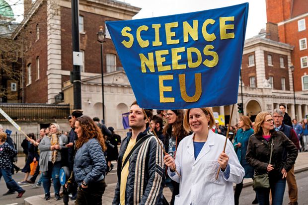 A protester holds a "Science needs EU" banner on a march and rally organised by the pro-European People's Vote campaign for a second EU referendum in Parliament Square, central London on March 23, 2019