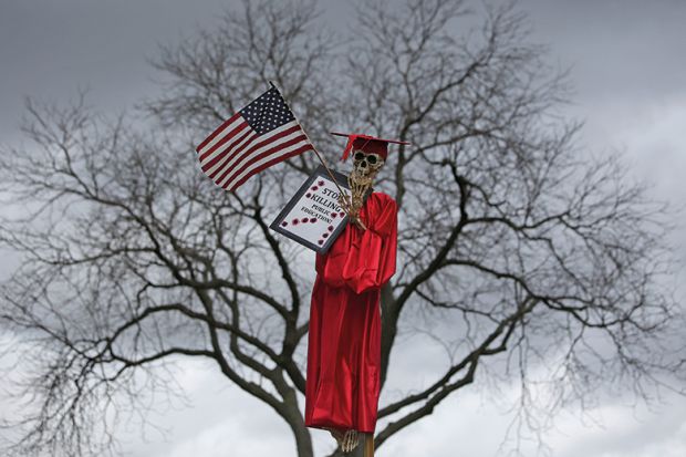 Skeleton wearing graduation gown in a tree. Northeastern Illinois University protest over funding