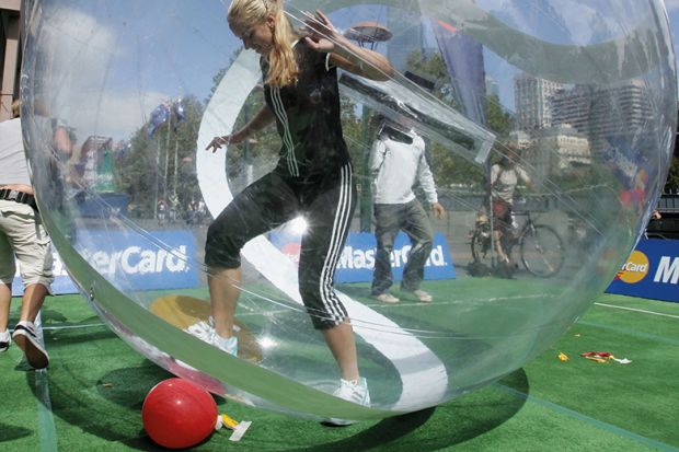 woman trying to kick ball from within a zorb ball / bubble