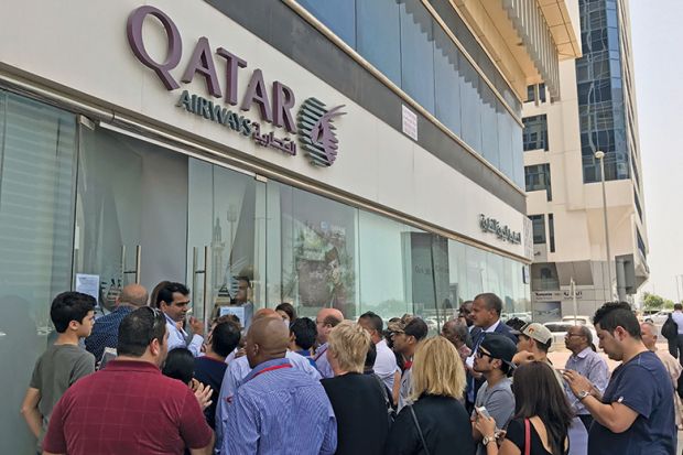 People gather outside a branch of Qatar Airways in the United Arab Emirate of Abu Dhabi on June 6 after ban on Qatari flights