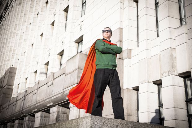 Caped geek superhero standing on pedestal
