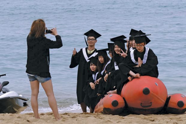 Students on inflatable boat on beach