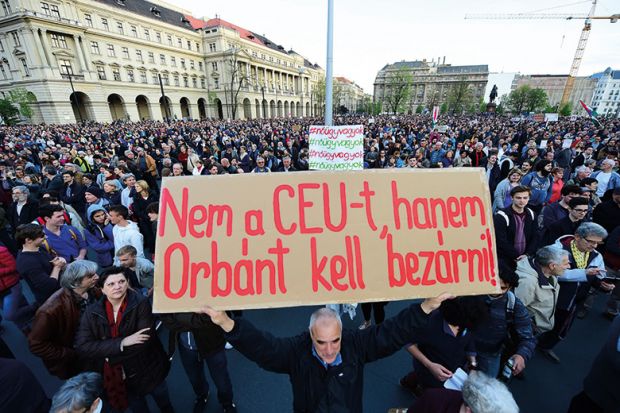 A man holds up a sign with the text 'Don't close CEU, Orban in to the jail" as students and teachers of the Central European University protest. Hungary