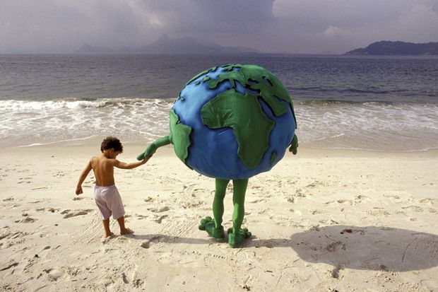 Little boy holding hands with person dressed as planet Earth