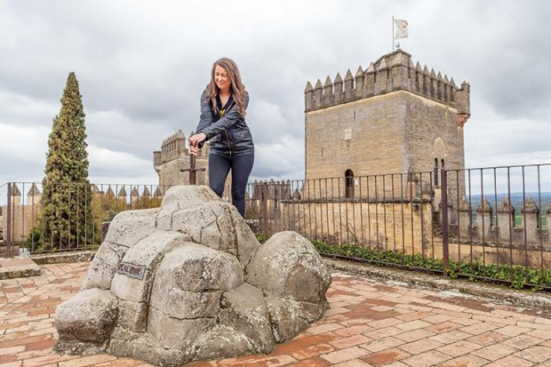 Woman pretends to pull King Arthur’s sword out of its stone