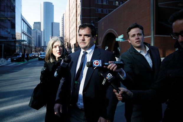 Stanford University sailing coach John Vandemoer, centre, is questioned by reporters as he leaves the John Joseph Moakley United States Courthouse in Boston on March 12, 2019. 