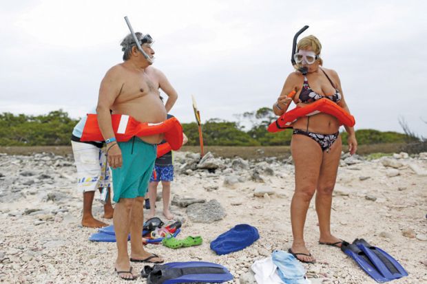 Tourists in rubber rings and flippers ready for snorkeling class