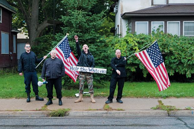 Neo-nazis holding American flag. White supremacists
