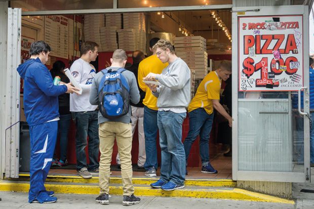 Group eating outside store selling pizza for one dollar
