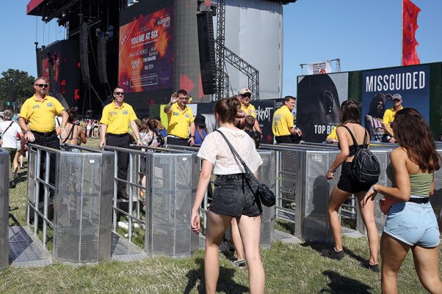 Music fans and security staff at the newly installed crowd control barriers at the Main Stage during day one of Reading Festival 2019
