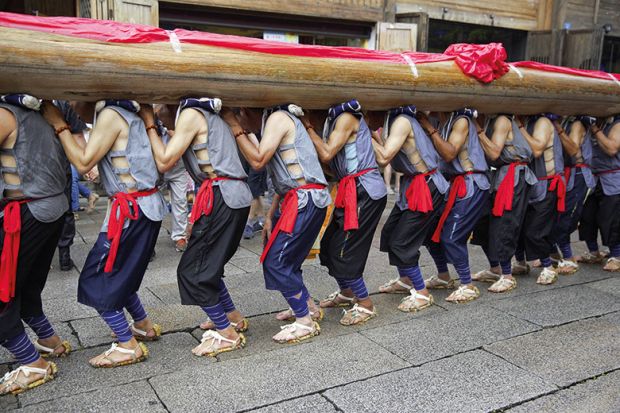 24 seniors villagers carry a giant wooden pillar ("long zhu" in Chinese) on their shoulders to celebrate the 11th China's Cultural Heritage Day on June 11, 2016 in Fuzhou, Fujian Province of China