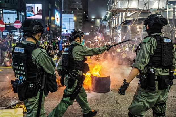 Police stand guard on a road to deter pro-democracy protesters from blocking roads in the Mong Kok district of Hong Kong on May 27, 2020, as the citys legislature debates over a law that bans insulting China's national anthem. Police stand guard on a road to deter pro-democracy protesters from blocking roads in the Mong Kok district of Hong Kong on May 27, 2020, as the citys legislature debates over a law that bans insulting China's national anthem.