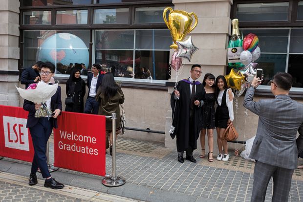 Friends and family of a 21 year-old Law graduate from Hong Kong, celebrate her graduation with a 2:1 degree outside the London School of Economics
