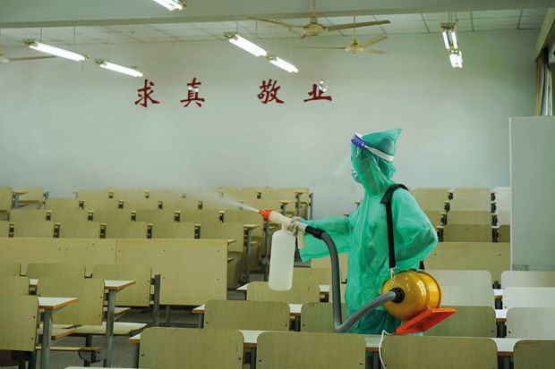 Worker sprays disinfectant inside a classroom of Zhejiang A&F University, August 2021
