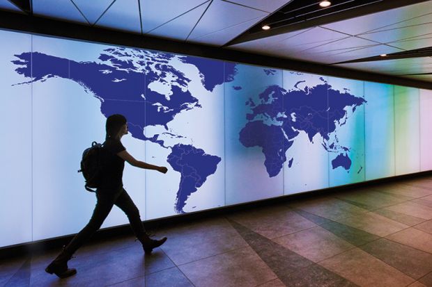 Person walking past map of the world