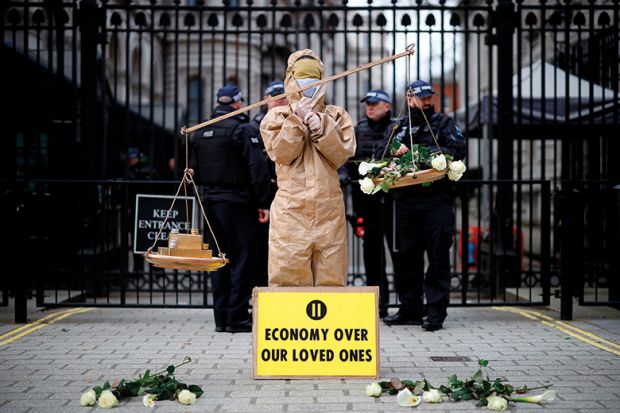 A protester from the group "Pause The System" stands beside the entrance to Downing Street in central London on March 17, 2020.
