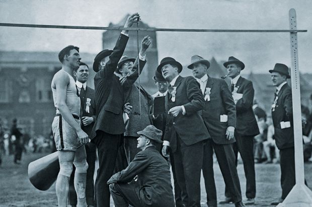 Officials measuring the high jump