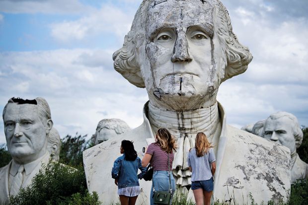 People tour the decaying remains of salvaged busts of former US Presidents Lyndon Johnson (L) and George Washington on August 25, 2019, in Williamsburg, Virginia.
