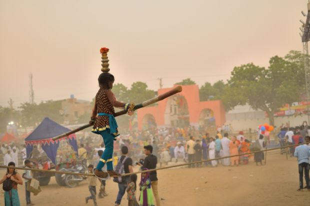 An Indian girl walks on a tightrope
