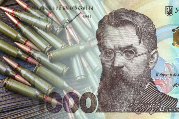 Ukrainian hryvnia against the background of machine gun cartridges