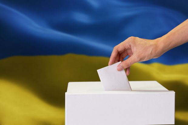 A ballot box in front of a Ukrainian flag