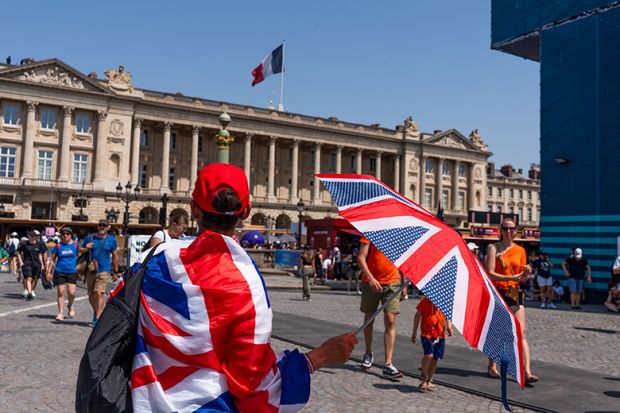 A spectator wrapped in a British Union flag shelters from the sun with an umbrella near the Paris 2024 Olympic Games Concorde stadium venue in Paris, France, 2024. To illustrate the return of the Erasmus+ programme.