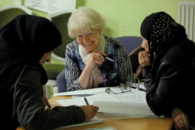Volunteer tutor instructs asylum applicants in foreign-language class