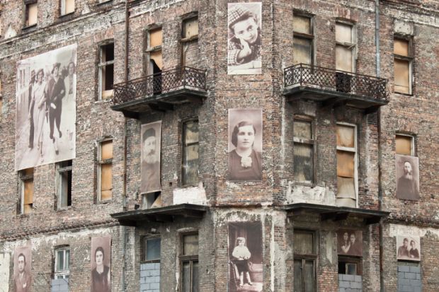 Warsaw, Poland - September 1, 2012 Holocaust memorial - a building from Warsaw ghetto with pictures of jews on the facade.