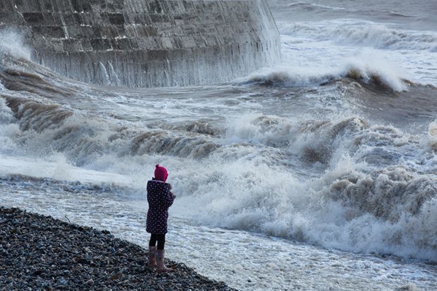 Waves breaking over the Cobb at Lyme Regis, Dorset, England