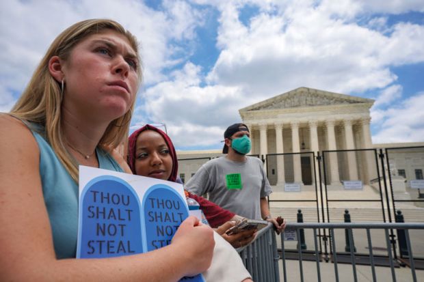 Abortion rights advocates Maddie and Rifal listen to protestors gathered outside the U.S. Supreme Court