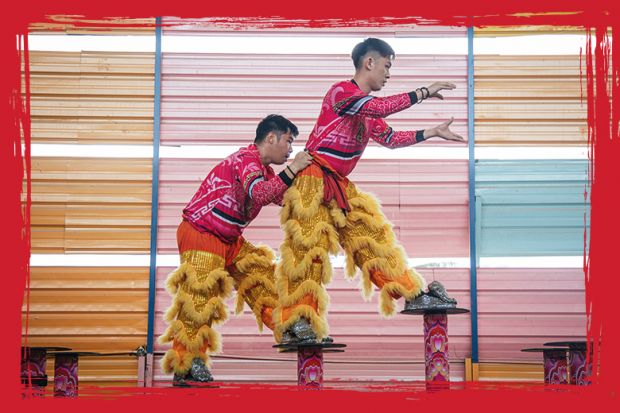 Lion dance performers seen during a closed rehearsal climbing up steps  in Kuala Lumpur, Malaysia to illustrate A bridge to all areas