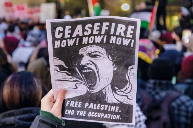 A pro-Palestinian protester carries a sign in Midtown Manhattan during a protest calling for a ceasefire between Israel and Hamas to illustrate US campuses try tolerance training to defuse Palestine protests