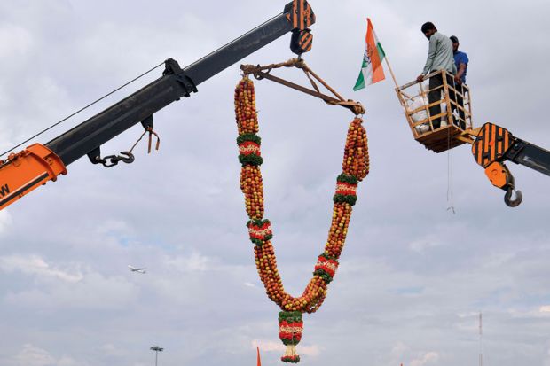 A 20-feet long apple garland is raised with a crane to welcome former Karnataka Minister D.K. Shivakumar, in Bangalore to illustrate No ‘rush to India’ by top-ranked universities, academics say