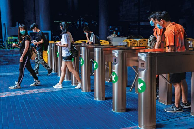 people walking through card operated turnstiles at the entrance to Hong Kong Polytechnic University to illustrate Lock out the inequities in global use of English 