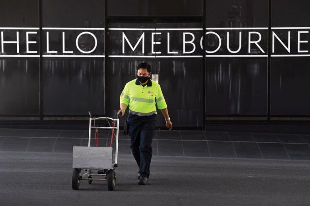 A man wields his empty trolly with sign reading 'Hello Melbourne' to illustrate Domestic demand shows signs of softening in Australia