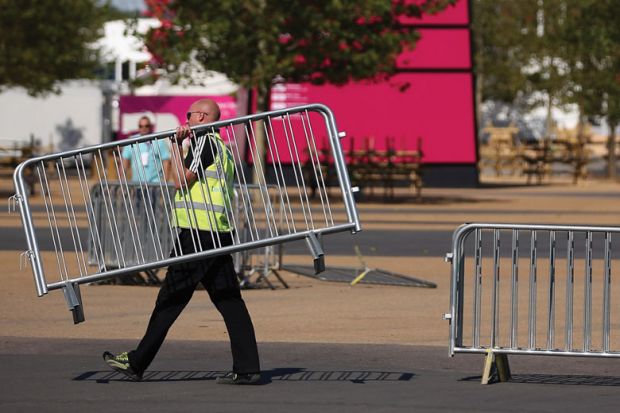  Workmen move barriers from outside the Olympic Stadium in Stratford