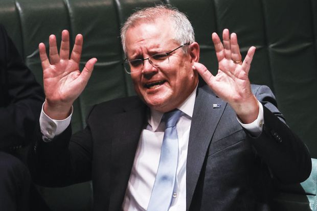 Australian Prime Minister Scott Morrison with both hands up to illustrate Australia parliament rejection.