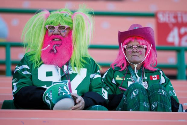 Two costumed Saskatchewan Roughrider fans to illustrate Canada’s universities tackle false claims of Indigenous identity