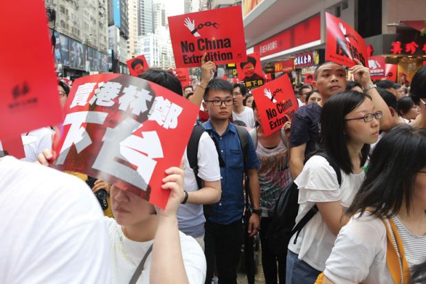 Demonstrators hold placards during the anti extradition march to illustrate Concerns Hong Kong students’ union faces on campus