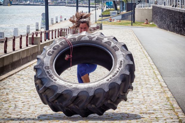 woman working out with a tractor tire in Rotterdam, The Netherlands to illustrate Recast Rutte coalition promises  to invest in tackling HE workloads