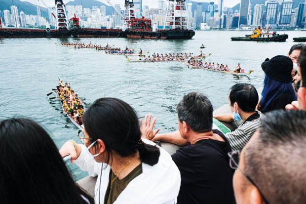 People watch the Hong Kong International Dragon Boat Race to illustrate Hong Kong could lift cap on non-locals