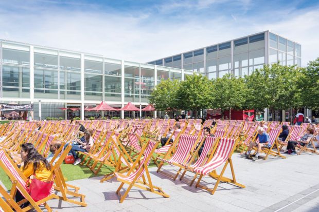 Outdoor deck chairs at Milton Keynes Shopping Centre to illustrate In-person teaching campus plan ‘meets demand’ as OU model creaks
