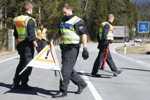 German police guards secure an access road to illustrate Language barrier holds back international academics in Germany