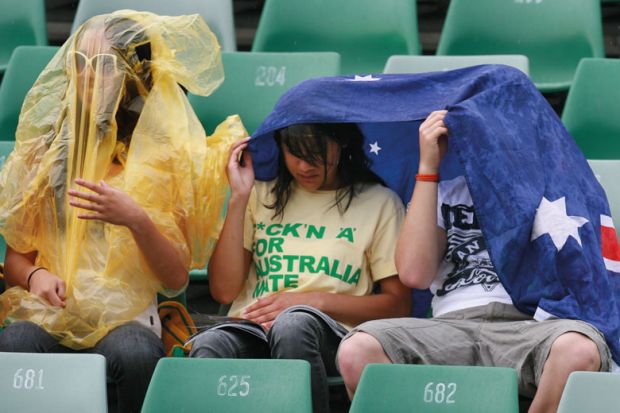 Spectators take temporary cover as rain stops play to illustrate Government will pilfer international levy proceeds, critics warn